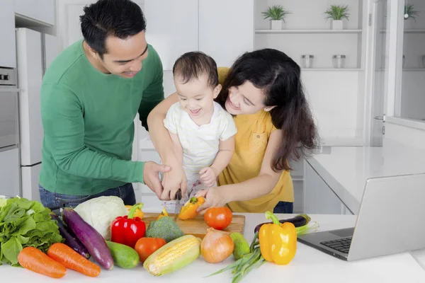 Glad ung familj förbereder måltid för middag — Stockfoto