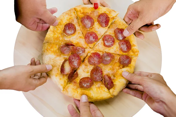 Blick von oben auf Hände, die Peperoni-Pizzascheiben vom Holzteller nehmen — Stockfoto