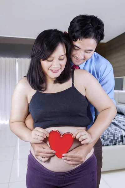 Kochający mąż przytula żonę w ciąży od tyłu — Zdjęcie stockowe