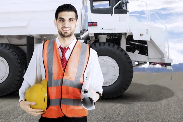 Kolen mijn ingenieur holding veiligheidshelm en papierwerk voor een grote witte mijnbouw vrachtwagen — Stockfoto