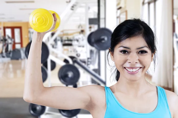 Bela ásia mulher sorrindo para câmara enquanto levantamento dumbbell — Fotografia de Stock