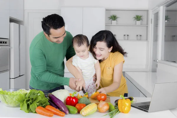 Feliz asiático mujer cortar verduras con hija y marido — Foto de Stock