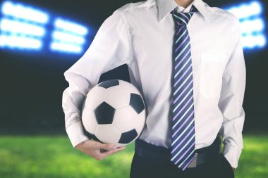 Kravat takıyor ve futbol topu tutan meçhul futbol kulübü Yöneticisi
