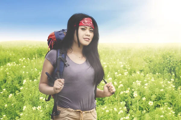 Ung kvinna som står i fältet blomma — Stockfoto
