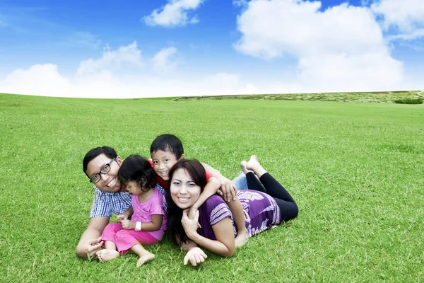 Jonge ouders met hun kinderen in het park spelen — Stockfoto