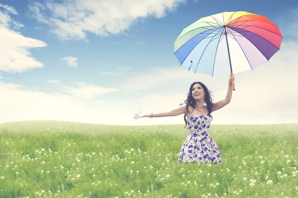 Beautiful young asian woman with umbrella on blossom field — Stock Photo, Image