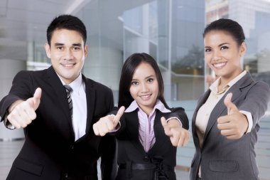 Gülümseyen ve başparmak gösterilmesini iş adamları