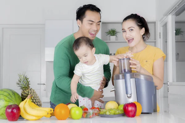 Söt dotter lär dig hur man gör fruktjuice med föräldrar — Stockfoto