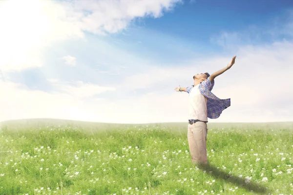 Hombre feliz con los brazos abiertos disfrutando de la primavera en el prado en flor . —  Fotos de Stock