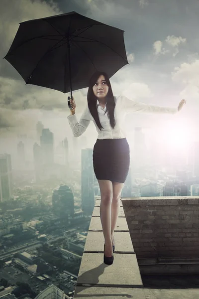 Beautiful entrepreneur with umbrella on rooftop — Stock Photo, Image