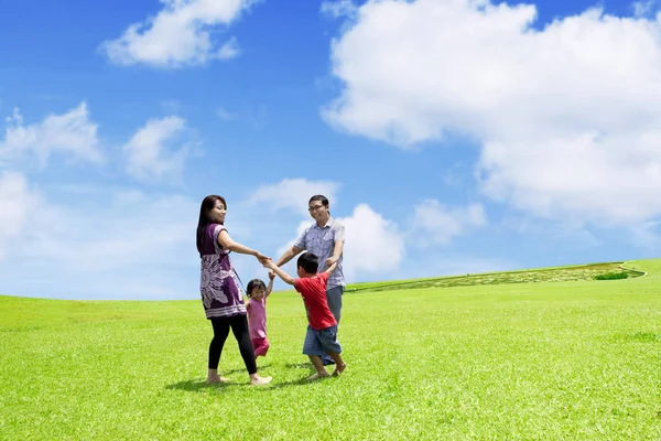 Familia feliz jugando juntos en el prado Imagen De Stock