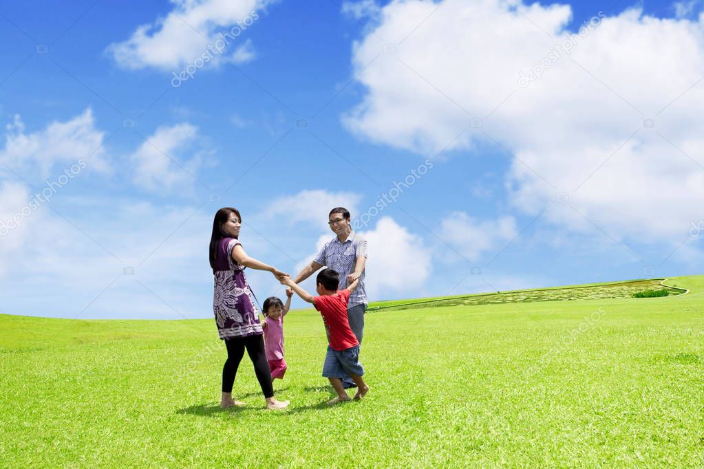 Happy family playing together in the meadow 