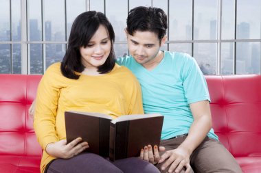 Sevgi dolu koca hamile karısıyla bir kitap okuma