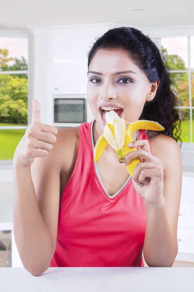 Frau isst Banane mit Herbsthintergrund — Stockfoto