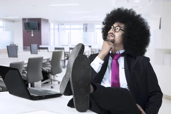 Afro-Amerikaanse zakenman met voeten op het Bureau denken — Stockfoto