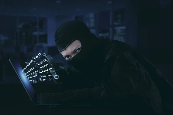 Hacker wearing mask trying to steal identity