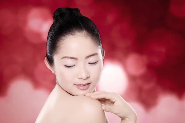 Schöne orientalische Frau mit makelloser Haut hält einen Make-up-Pinsel — Stockfoto