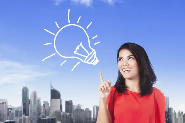 Young businesswoman with bulb symbol — Stock Photo, Image