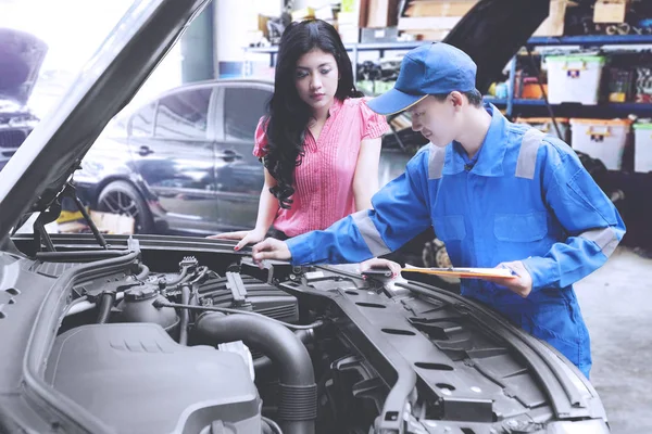 Mechanic helping a customer fixing a car — Stock Photo, Image