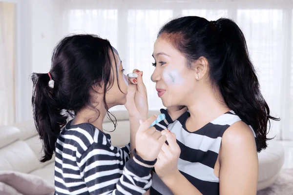 Mãe e filha se divertindo com pintura facial — Fotografia de Stock