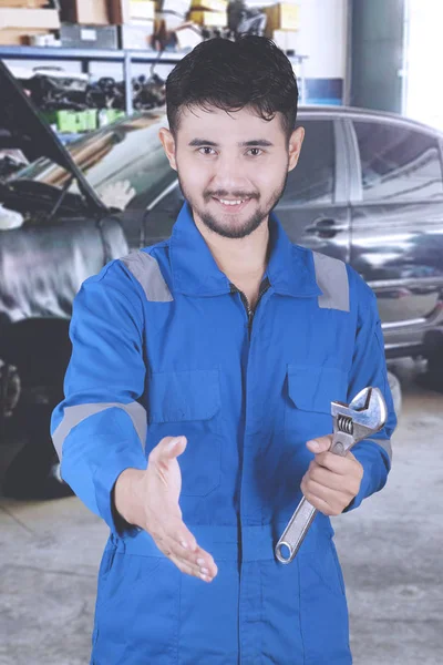 Jovem amigável mecânico oferecendo aperto de mão — Fotografia de Stock