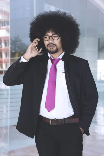 Hombre de negocios afroamericano con cabello afro hablando por teléfono —  Fotos de Stock
