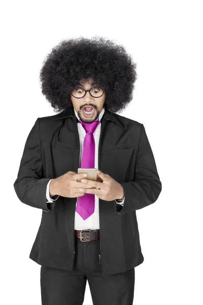 Afro zakenman kijkt geschokt met smartphone — Stockfoto