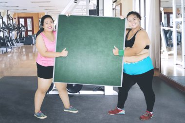 Spor Merkezi pano ile iki kadın