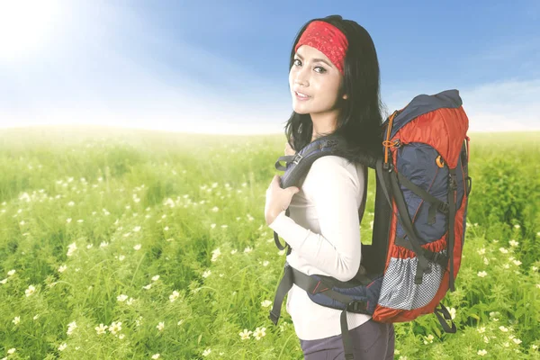 Turist kadın çiçek alanındaki sırt çantası ile — Stok fotoğraf