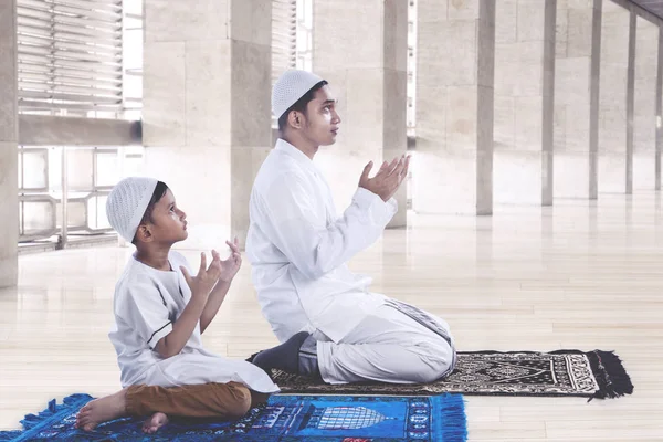 Muslim father and son praying together — Stock Photo, Image