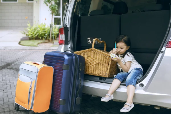 Menina bonita com malas sentadas em um carro — Fotografia de Stock