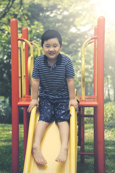 Glücklicher kleiner Junge, der mit einer Rutsche spielt — Stockfoto