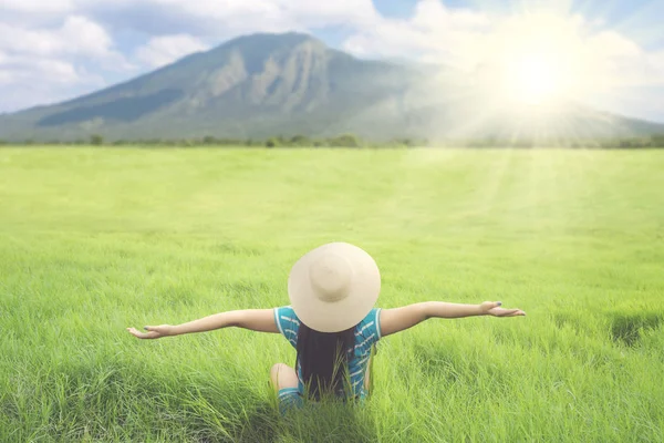 Female tourist stretching her hands on the meadow — Stock Photo, Image