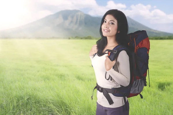 Female tourist carrying a backpack on mountain — Stock Photo, Image