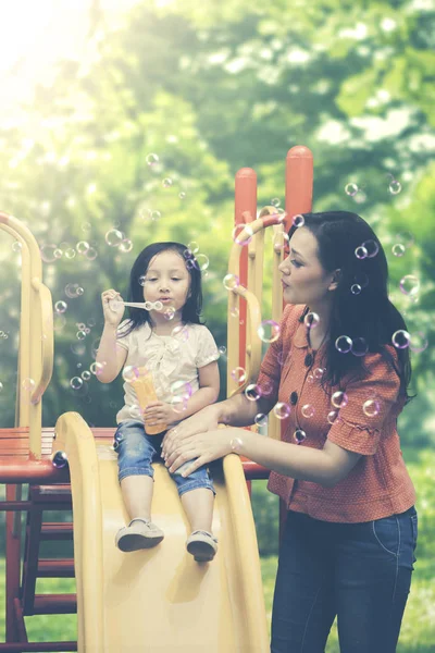 Niño y madre con burbuja de jabón en el parque —  Fotos de Stock