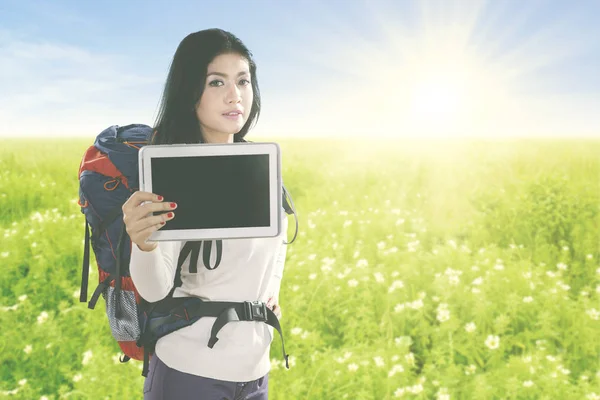 Belo viajante com tablet no prado da flor — Fotografia de Stock