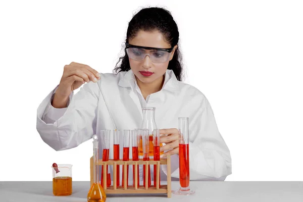 Schöne Wissenschaftlerin mischt Chemikerin Flüssigkeit im Studio — Stockfoto