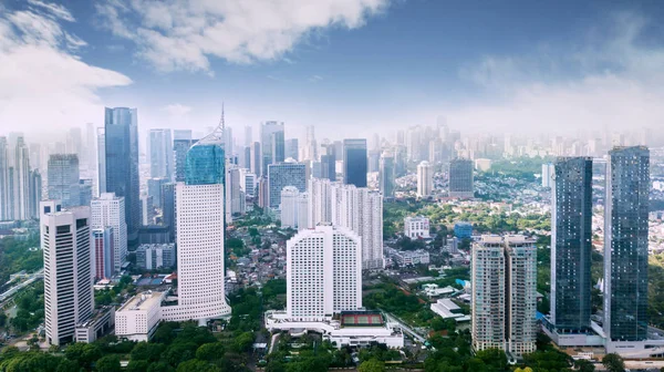 Belvárosi Jakarta-városkép felhőkarcolók és lakóházak, kék ég alatt — Stock Fotó