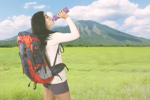 Beautiful hiker woman drinking in the mountain — Stock Photo, Image