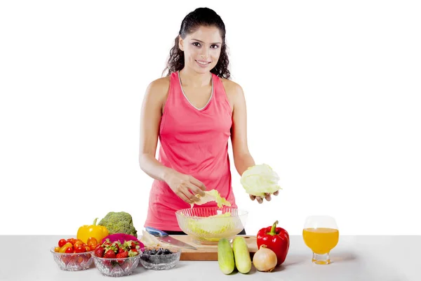 Afrikaanse vrouw maken van gezonde salade op studio — Stockfoto