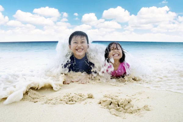 Två barn njuta av semester på stranden — Stockfoto