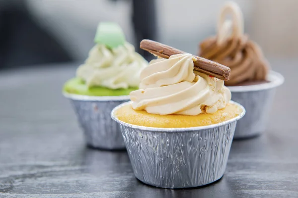 Drei leckere Cupcakes auf dem Tisch — Stockfoto