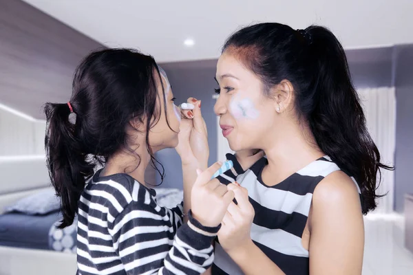 Madre con niño haciendo pintura facial —  Fotos de Stock