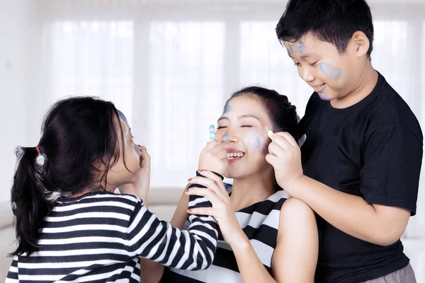 Mother and children playing with face painting — Stock Photo, Image