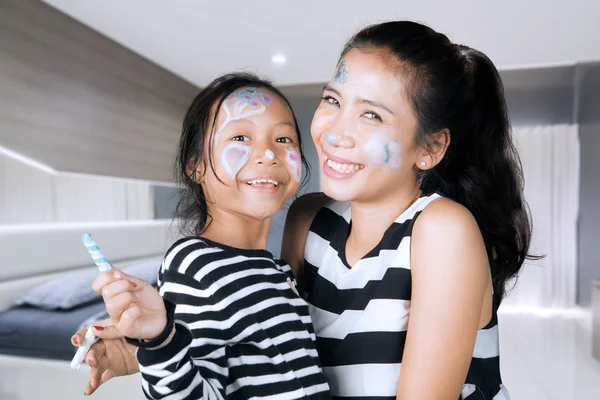 Mãe e criança brincando com pintura facial — Fotografia de Stock