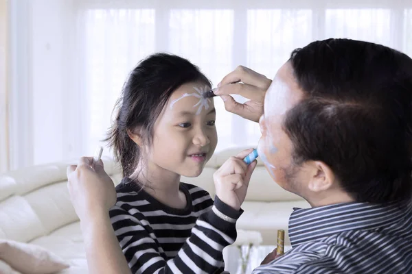 Klein meisje en haar vader doen schminken — Stockfoto