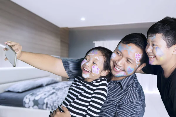 Vader en kinderen het nemen van foto in de slaapkamer — Stockfoto