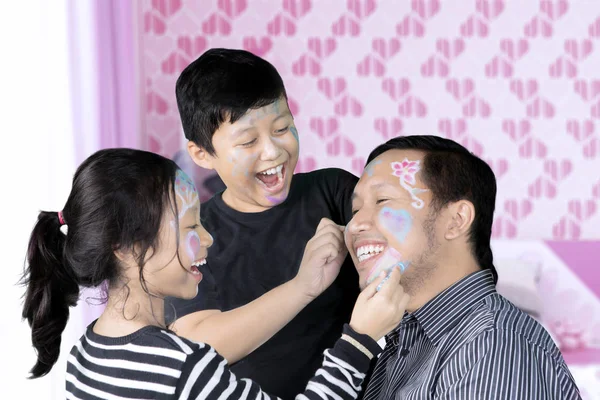 Padre e hijos jugando con la pintura facial — Foto de Stock