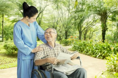 Kadın hemşire yaşlı bir adam ile konuşma