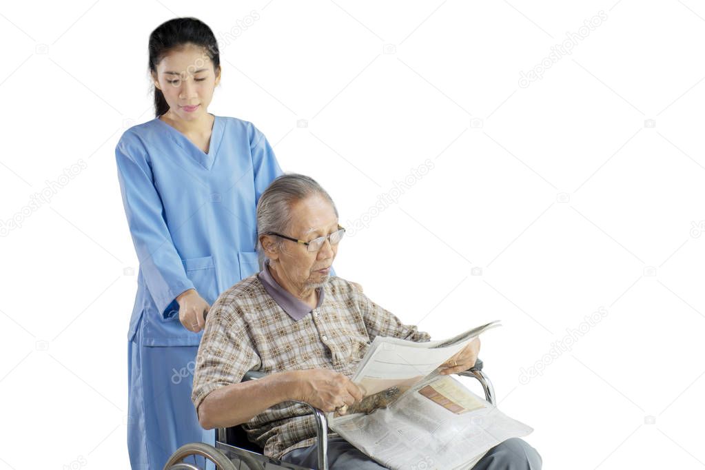 Old man and his nurse with newspaper